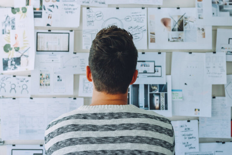 Man standing in front of a bulletin board